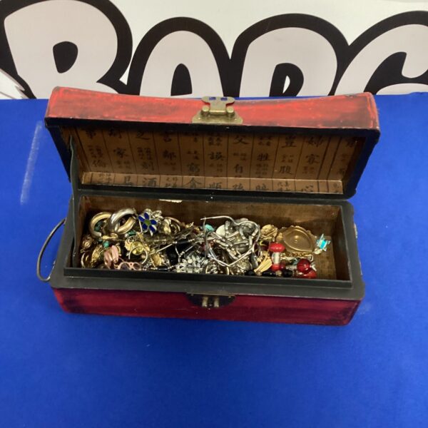 Open ornate wooden jewellery box filled with vintage jewellery and trinkets.