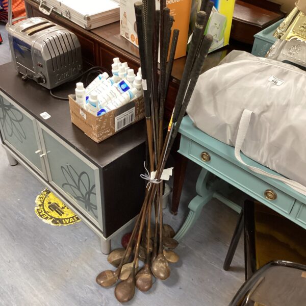 Selection of vintage golf clubs with wooden shafts.