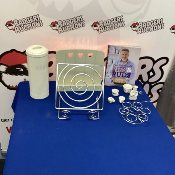 Stainless steel recipe stand with white egg holder on display.