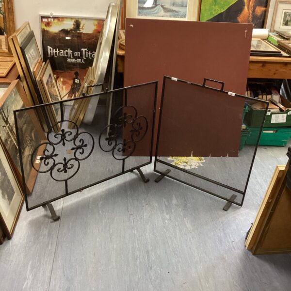 Pair of vintage wrought iron fire guards with scrolling details.