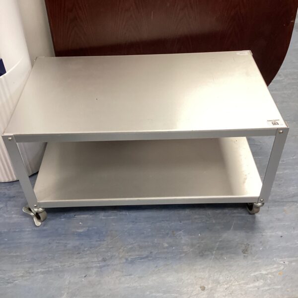 Stainless steel catering table on wheels for kitchen use.