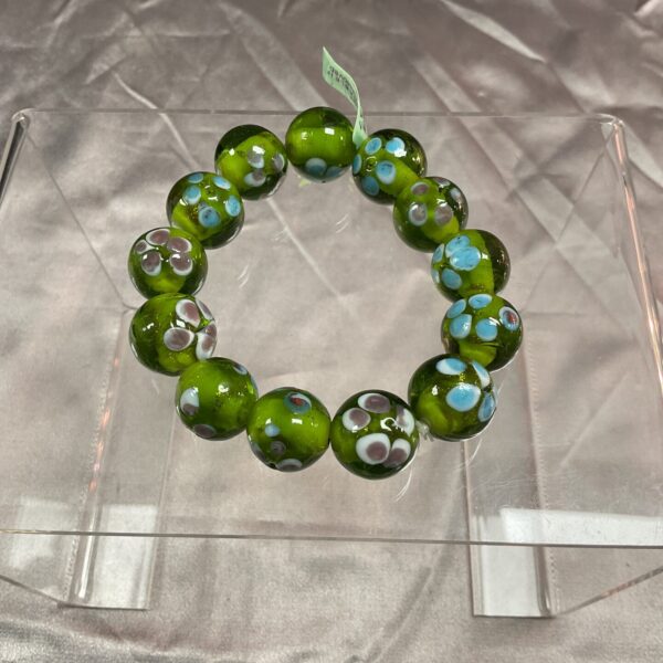 Vibrant green Murano glass bracelet with hand-painted floral details.