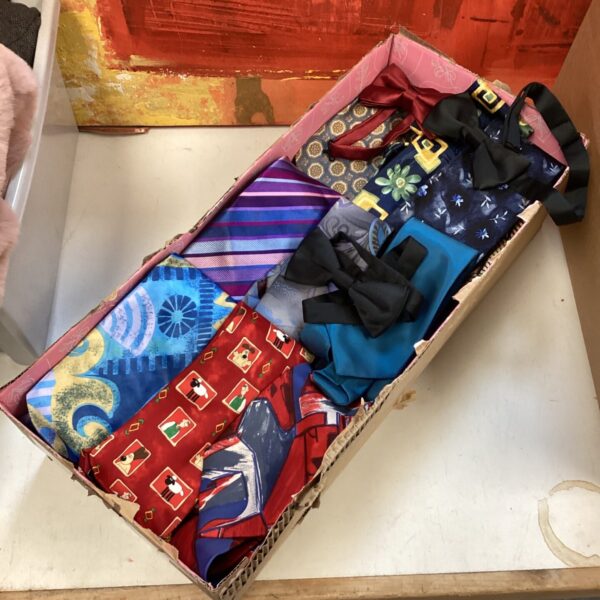 Assorted ties in a box, including silk and novelty designs.