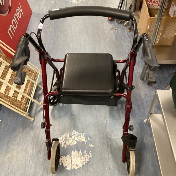 Red mobility walker with seat and shopping basket for assisted living.