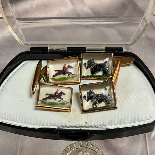 Vintage Scottie dog and hunting cufflinks on display.
