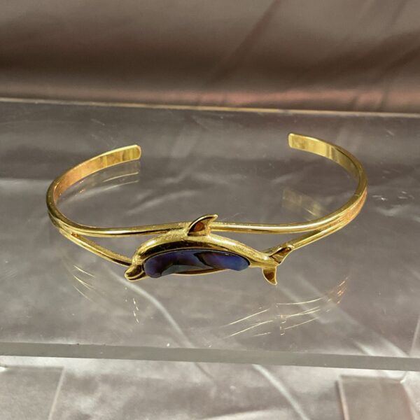 Vintage yellow metal dolphin bracelet with butterfly wing inlay.