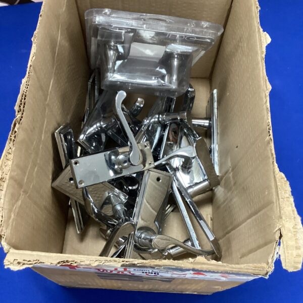 Assortment of chrome door handles in a cardboard box.