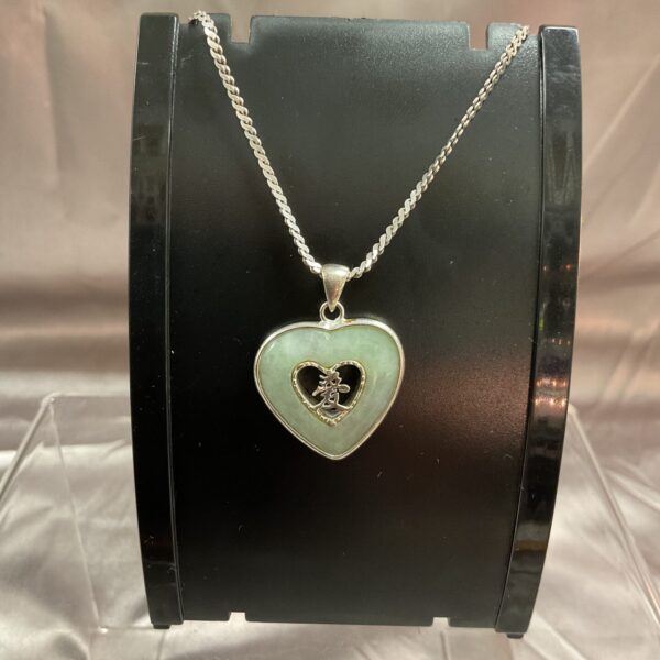 Silver necklace with a green jade heart pendant.
