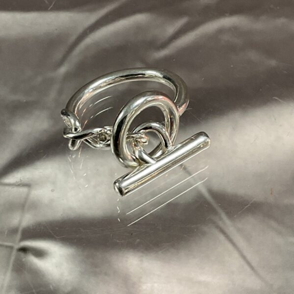 Close-up of silver D’Ancre ring with chain link detail.