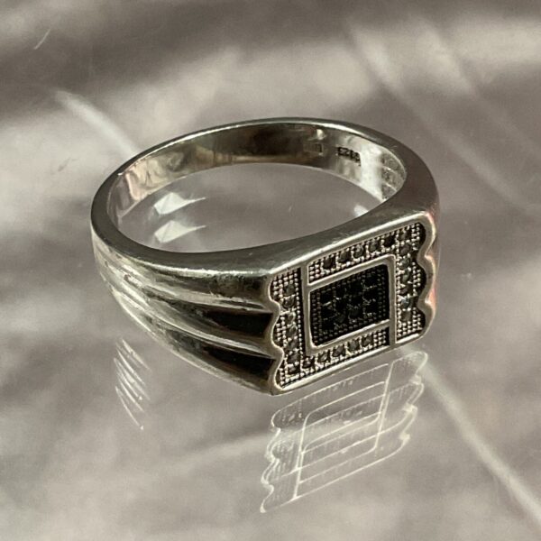Silver gents ring with a black stone setting.