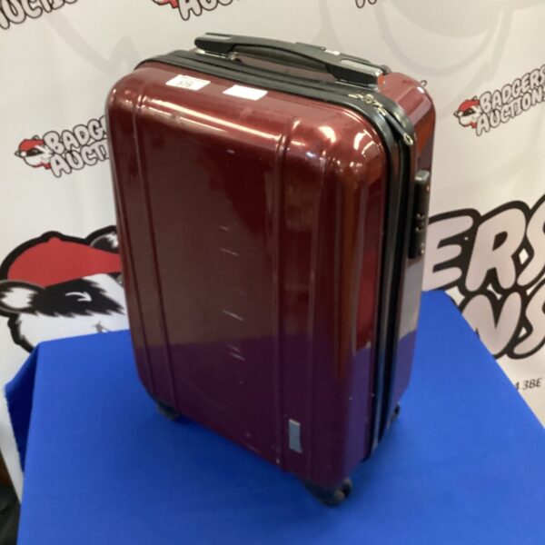 Vintage burgundy hard shell wheeled suitcase for travel.