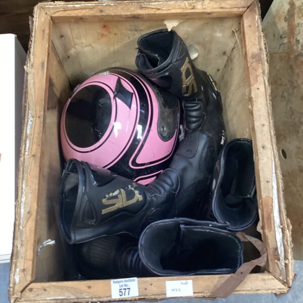 Motorcycle helmets and Sidi boots in a wooden crate.