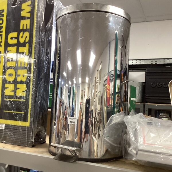 Large stainless steel kitchen bin with foot pedal mechanism.