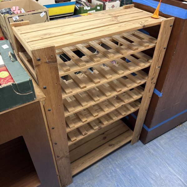 Vintage pine bottle rack for kitchen storage.