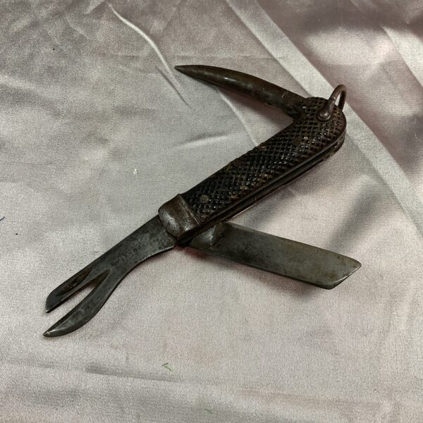 Open WWII military jack knife showing multiple blades and textured handle.