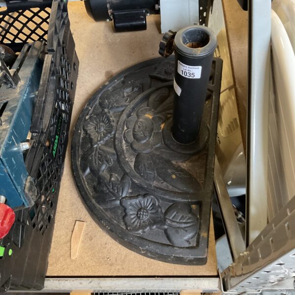 Decorative cast iron garden umbrella base for patio use.