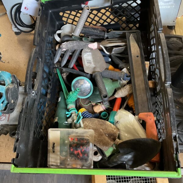 A box of used gardening tools including trowels and secateurs.