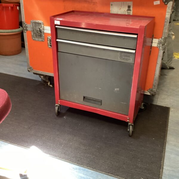 Red metal tool chest on wheels for workshop storage.