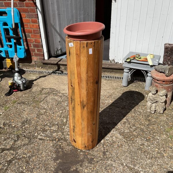 Rustic wooden plant stand in a garden setting.