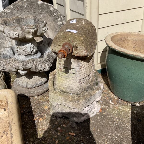 Weathered concrete windmill garden ornament for outdoor display.
