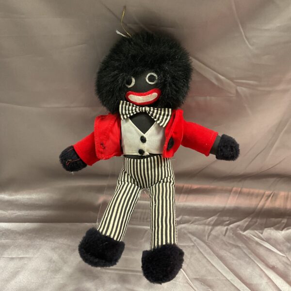Front view of a vintage Golly doll with striped trousers.