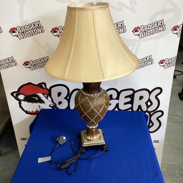 Vintage table lamp with detailed floral ceramic base and pleated shade.
