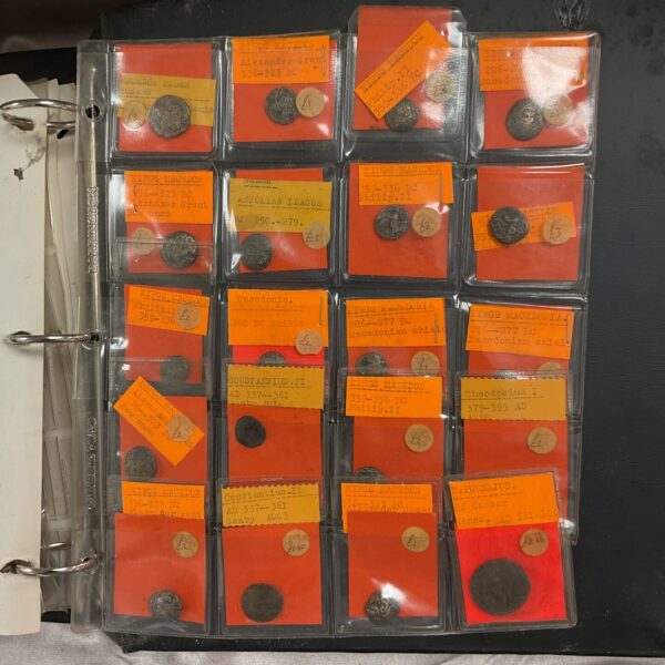Full view of ancient coin album with various coins visible.
