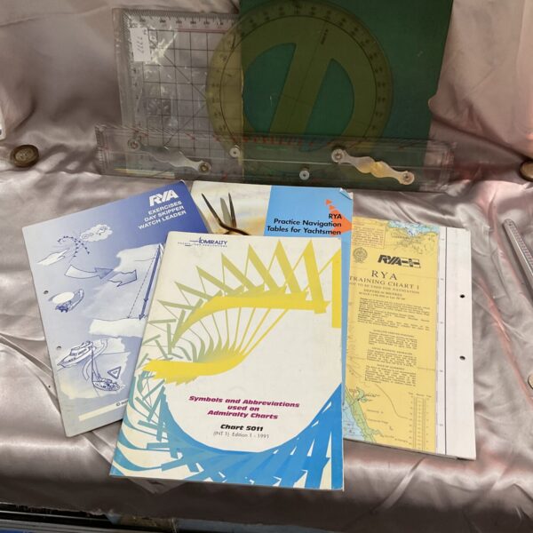 Nautical navigation tools and RYA training chart for maritime skills.