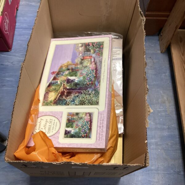 Vintage floral collectible placemats in a cardboard box.