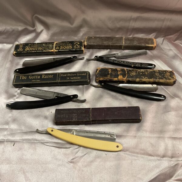 Vintage straight razor with dark handle, collectible antique shaving tool.