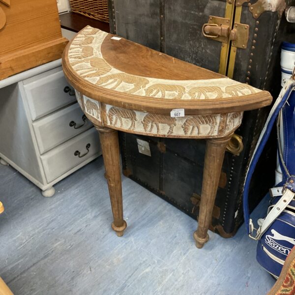 Antique demilune hall table with detailed zebra carving, needing restoration.