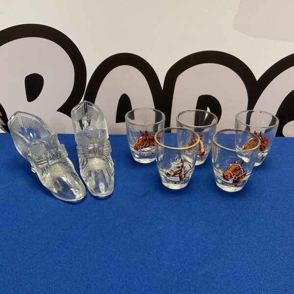Vintage horse motif shot glasses and glass shoes displayed together.