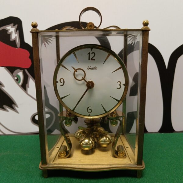 Vintage Kundo anniversary clock with brass and glass casing.