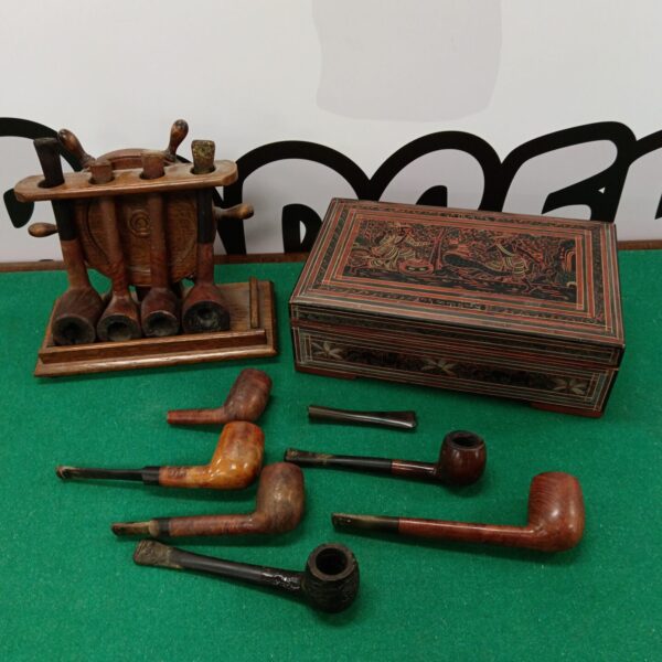 Vintage pipe collection displayed on a ships wheel rack.