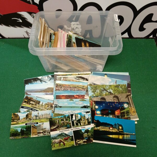 Vintage British postcards in a clear plastic container.