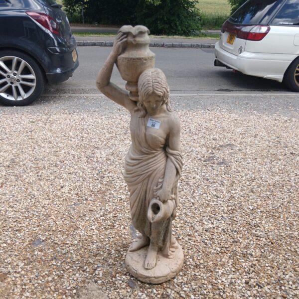 Stone garden water feature depicting a young woman with a vessel.