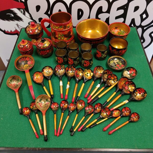 Vibrant Khokhloma lacquered ware collection with spoons and bowls.