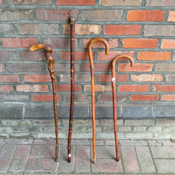 Lot of four vintage wooden walking sticks with unique handles.