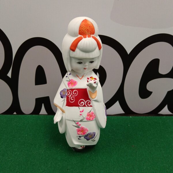 Vintage porcelain geisha figurine with detailed kimono and hairstyle.