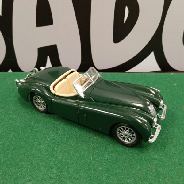 Green Burago Jaguar XK120 diecast model car on display.