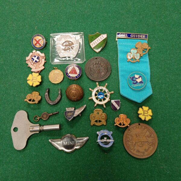 Vintage collection of badges and coins, including scouting and guiding memorabilia.