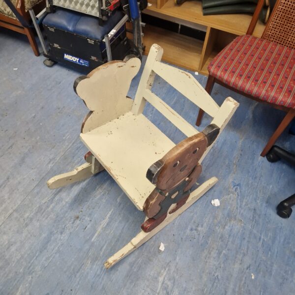 Vintage child's bear rocking chair in a playroom setting.