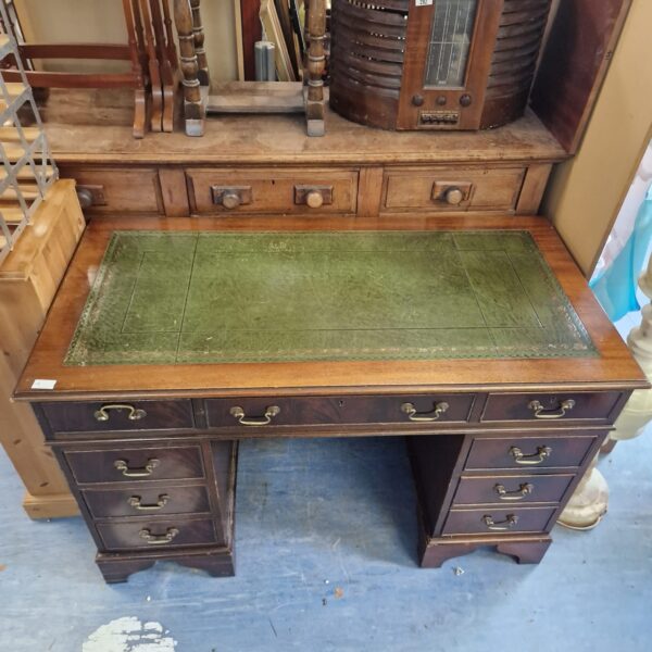Vintage mahogany writing desk with leather top and drawers.