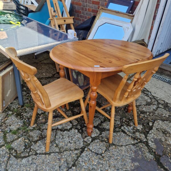 Small pine dining set with table and two chairs.