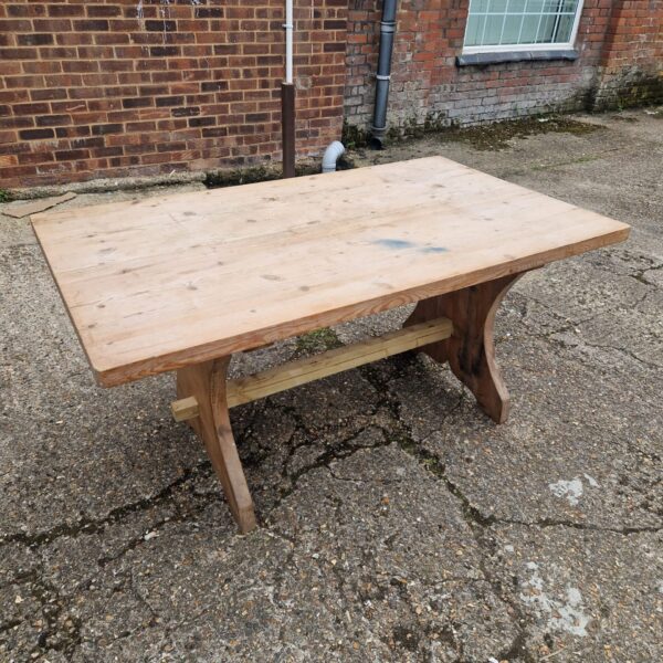Rustic pine dining table with farmhouse style and visible wear.