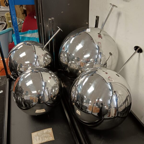 Set of four chrome garden balls in varying sizes.