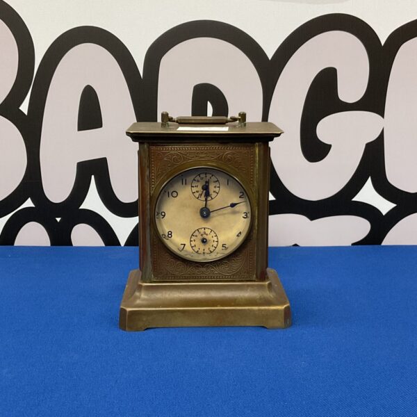 Ornate vintage musical carriage clock on blue background.