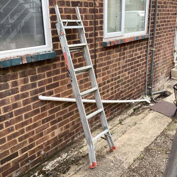 Silver Clima 3-way extending ladder leaning against a brick wall.