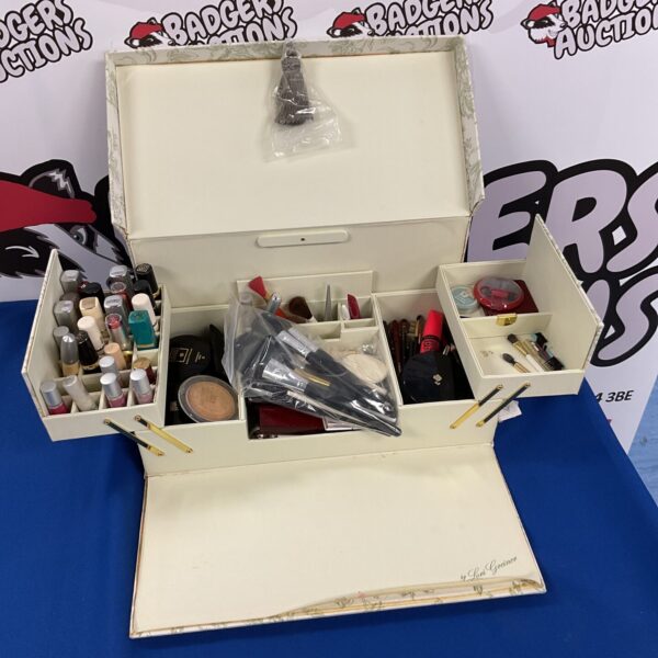 Open vintage fabric makeup box with cosmetics inside.
