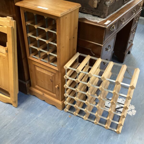 Antique pine cupboard with wine rack openings for bottle storage.